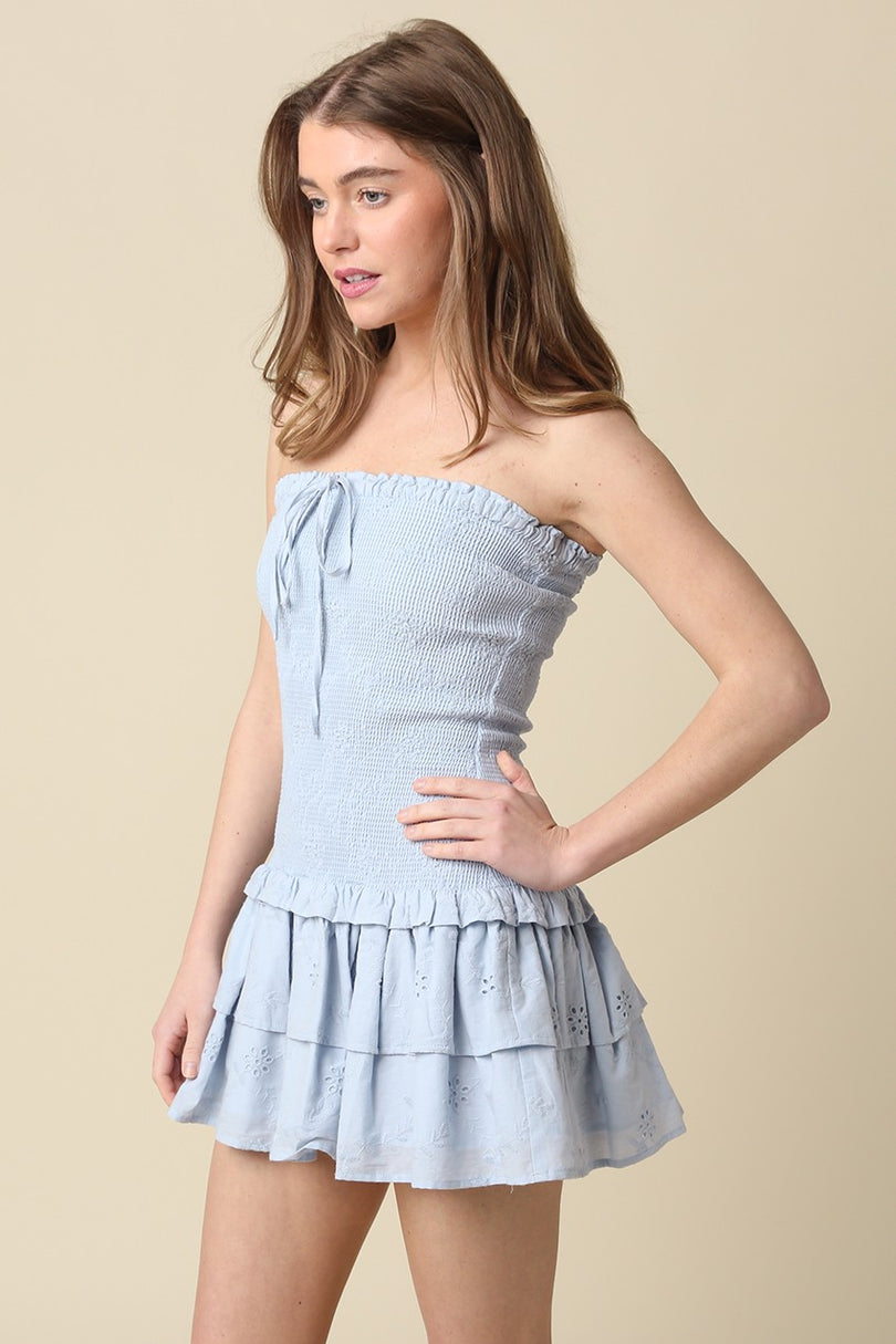 Side view of the Aimee light blue eyelet mini dress showing the drop-waist silhouette and tiered ruffle hem