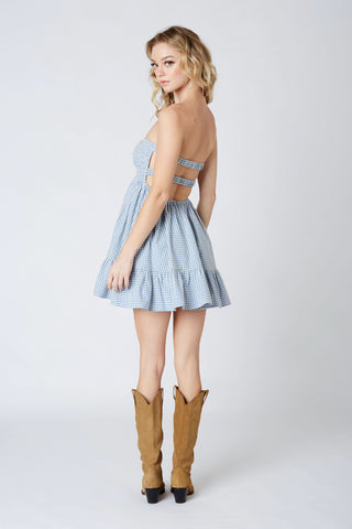 Side angle of blue gingham romper dress with open back and elastic straps 