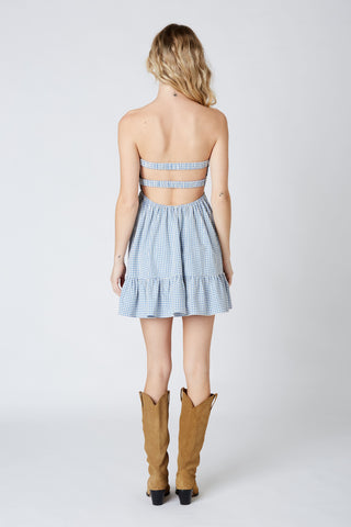 Back view of blue gingham romper dress with open back and elastic straps 