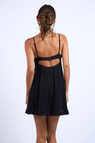 A short, black dress with a babydoll silhouette - back view