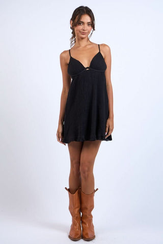 Model wearing a black mini dress for party styled with cowgirl boots