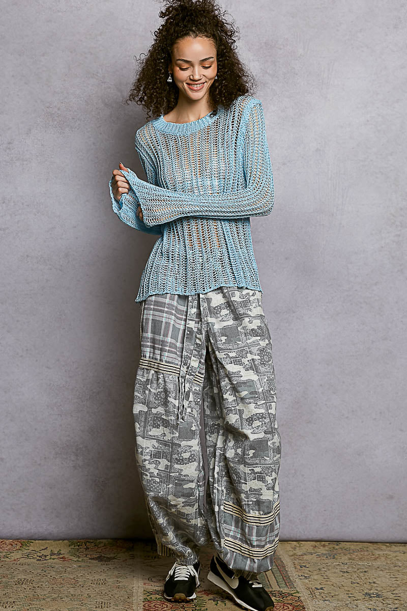 Full body view of the Sola blue sheer sweater styled as a coastal beach outfit