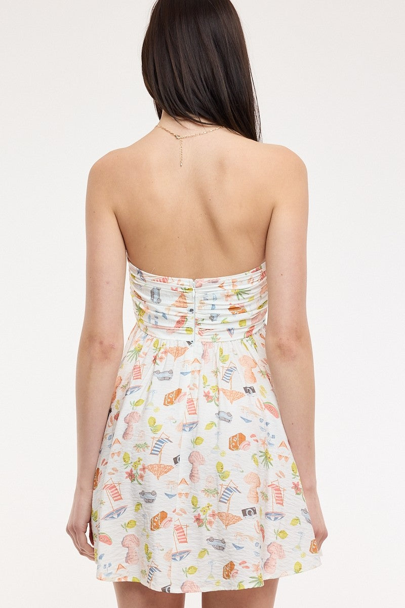 Back view of the strapless babydoll dress in a colorful postcard print with vintage cars and fruit