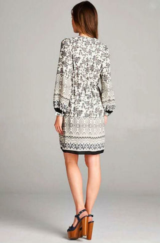 Back view of a long sleeve floral mini dress showing the tailored fit and hemline
