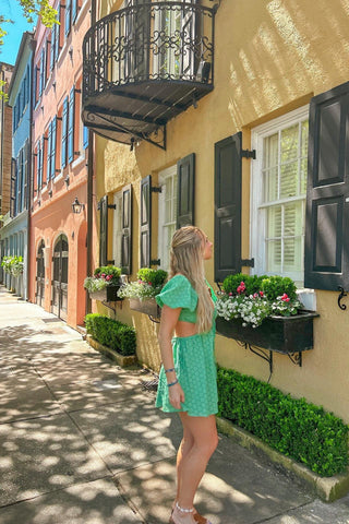 Green puff sleeve mini dress with cutout waist styled on a sunny Charleston street 