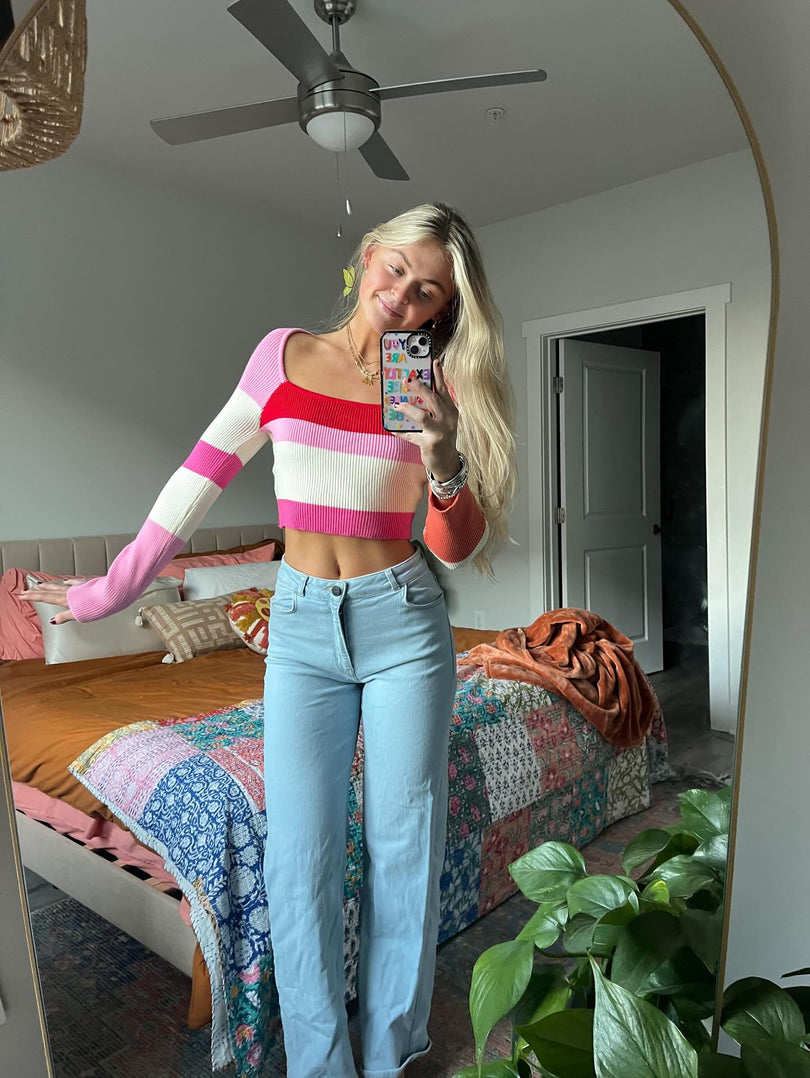 Model taking a selfie in the On Repeat Cropped Sweater in a bedroom setting
