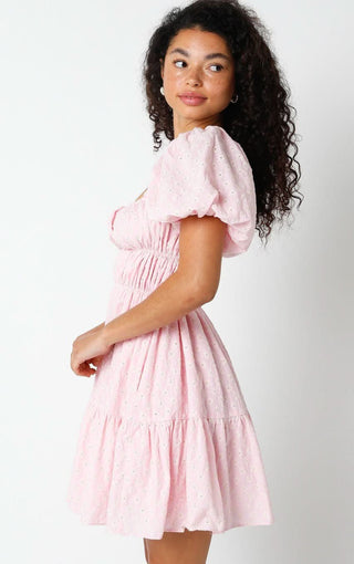 Side view of a pink puff sleeve eyelet dress showing the voluminous short sleeves and flirty mini length