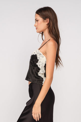 Side view of a black satin lace tank top showing the adjustable straps and cropped fit