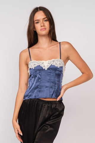 Woman wearing the Lucy navy satin lace camisole with white lace trim and bustier bodice
