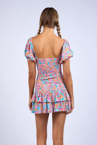 Back view of Mimi floral dress showing tiered ruffle skirt and smocked waist