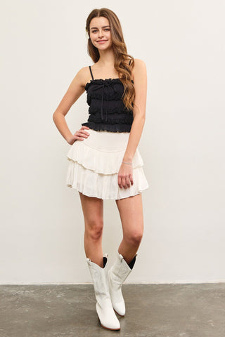 White mini skort styled with black top and boots