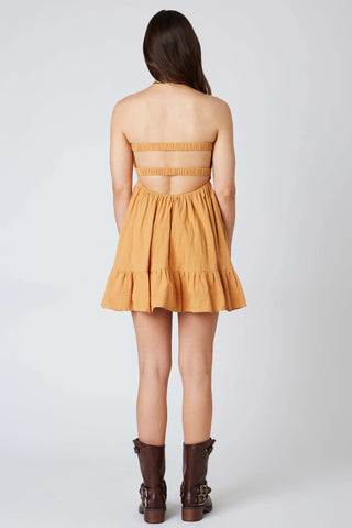 Back view of mustard yellow romper dress showing open back and elastic straps 