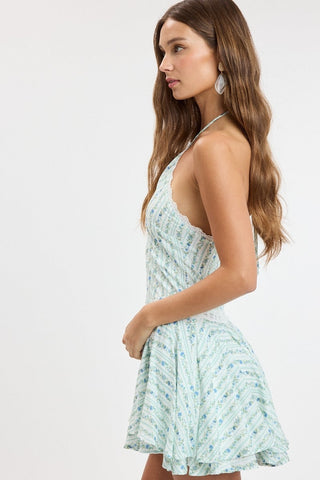 Side view of the Naya blue floral fit-and-flare dress showing the tiered ruffle hem