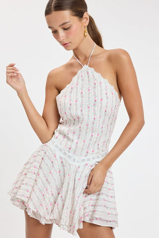 Close up of cute pink floral mini dress fabric with white lace trim at waist and neckline