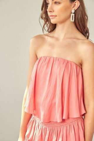 Close-up of the tiered ruffle detail on the Monaco Coral Strapless Romper, a vibrant coral vacation outfit
