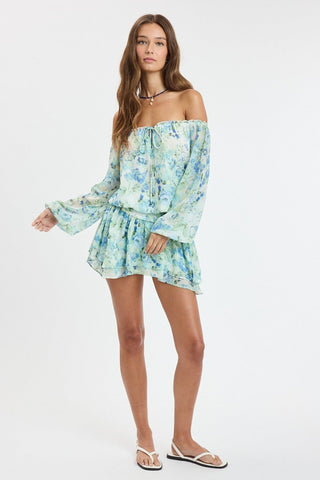 Full body shot of model wearing the Pixie Blue Watercolor Floral Off-the-Shoulder Romper Dress for summer