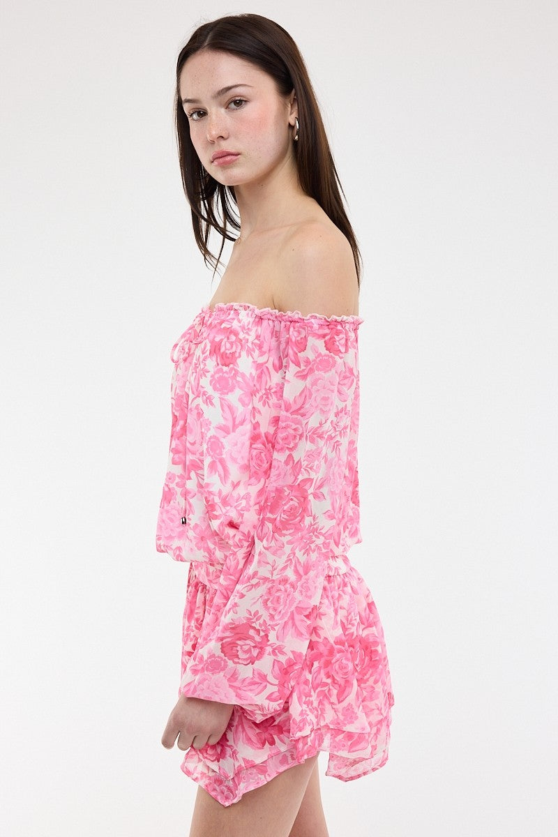 Side view of the pink floral romper dress highlighting the fitted waist and ruffle mini skirt
