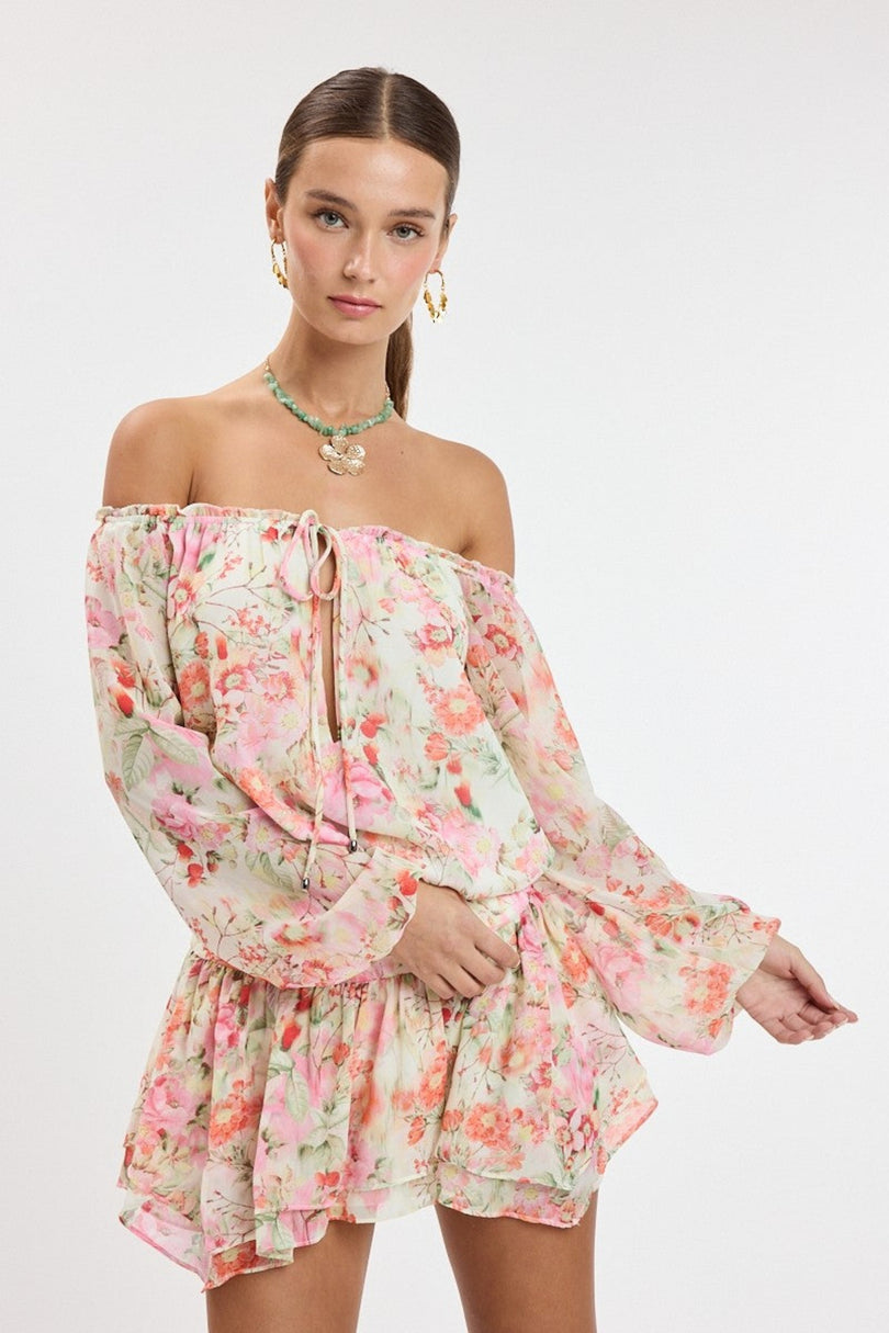 Front view of the Pixie Pink Watercolor Floral Off-the-Shoulder Romper Dress featuring a ruffled mini skirt
