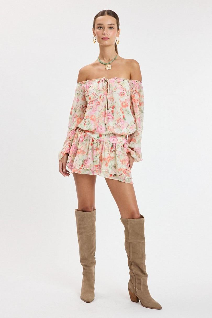 Full body shot of model wearing the Pixie Pink Floral Off-the-Shoulder Romper Dress styled with knee-high boots