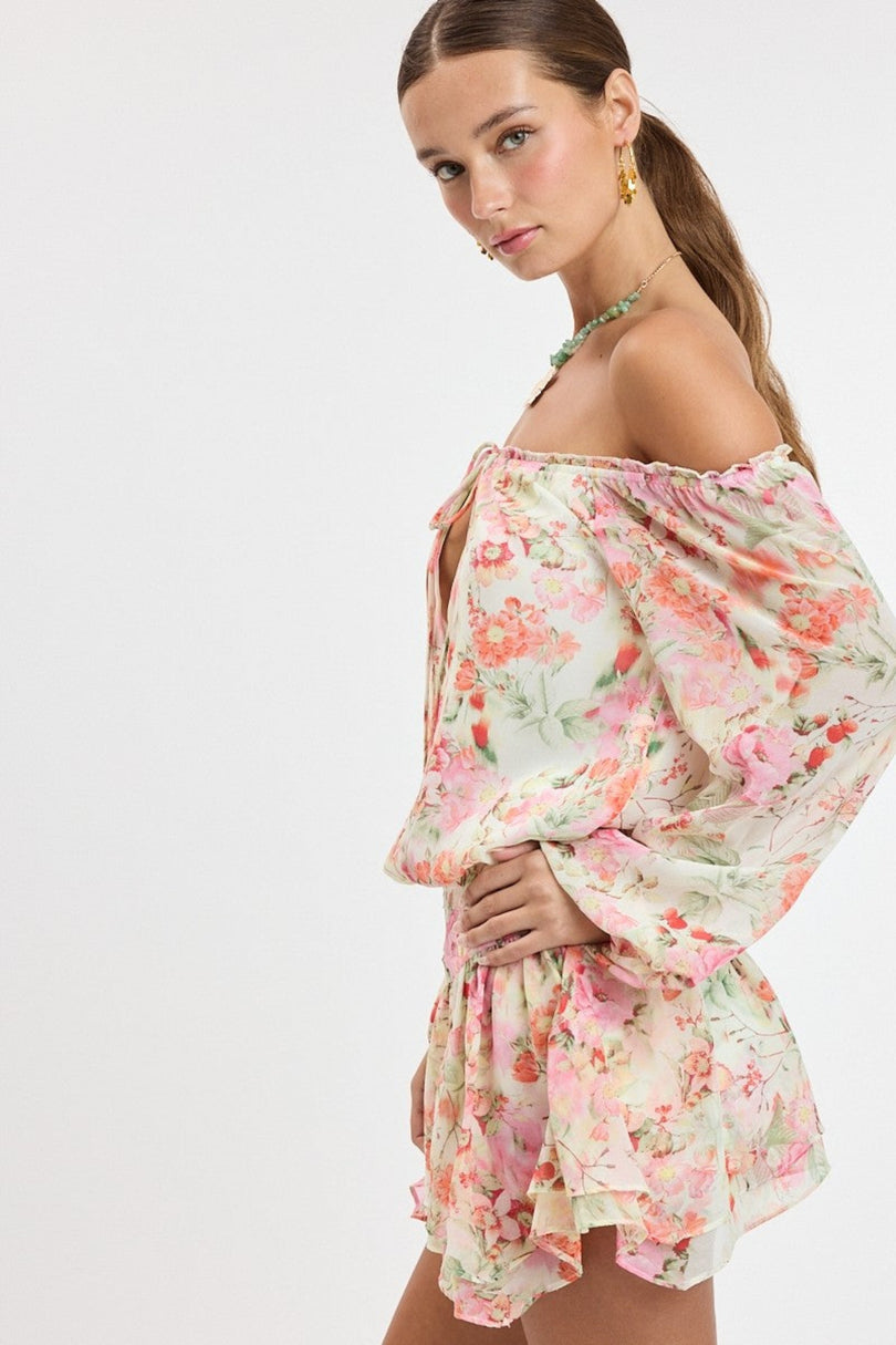 Side view of the Pixie pink floral romper dress showing the long balloon sleeves and fitted drop-waist silhouette