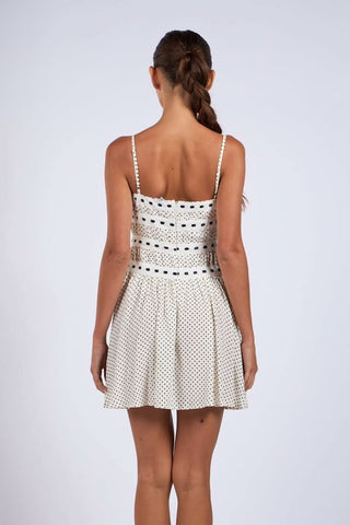 White polka dot cami dress with adjustable straps and flared skirt