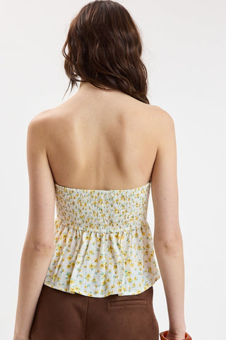 Back view of the yellow floral strapless top highlighting the smocked panel for a stretchy and comfortable fit