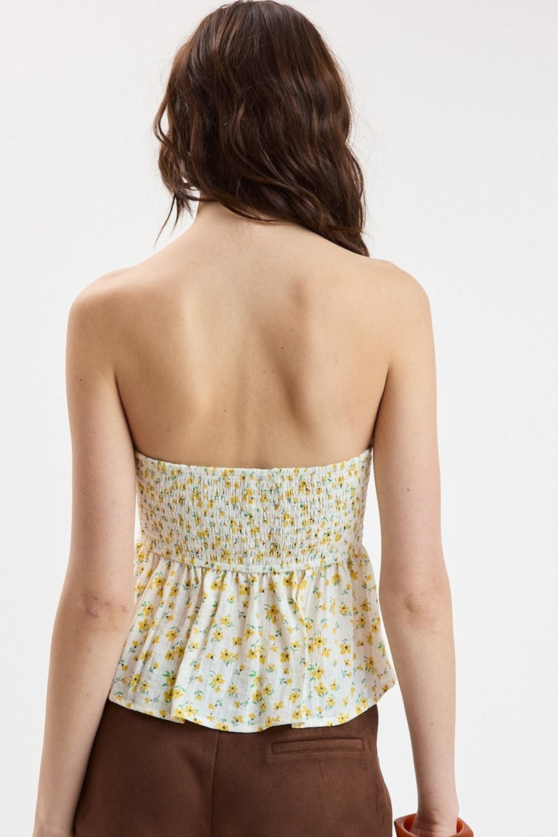 Back view of the yellow floral strapless top highlighting the smocked panel for a stretchy and comfortable fit