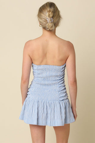 Back view of Taryn Blue Gingham Strapless Mini Dress highlighting the stretchy smocked back panel