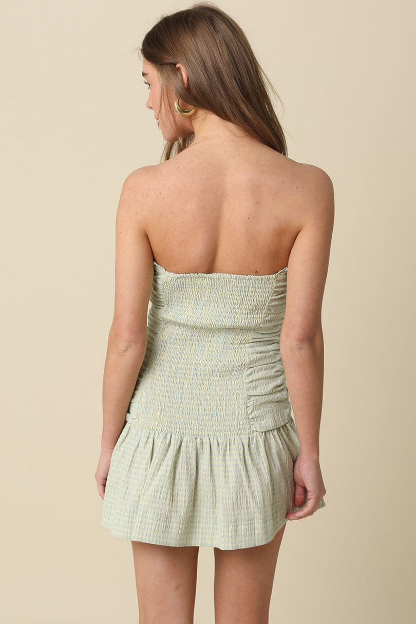 Back view of the Taryn Green Gingham Strapless Mini Dress showing the smocked elastic back detail