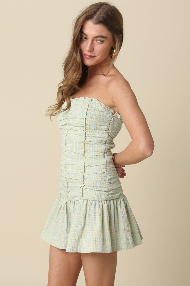 Side profile of the Taryn Green Gingham Strapless Mini Dress showcasing the flared skirt silhouette