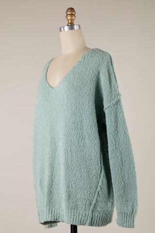 Oversized minit v-neck sweater with relaxed drop shoulder fit on model.