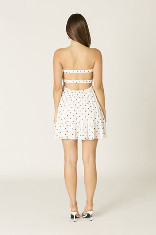 Full back view of the white and navy strapless romper highlighting the comfortable built-in shorts and babydoll fit