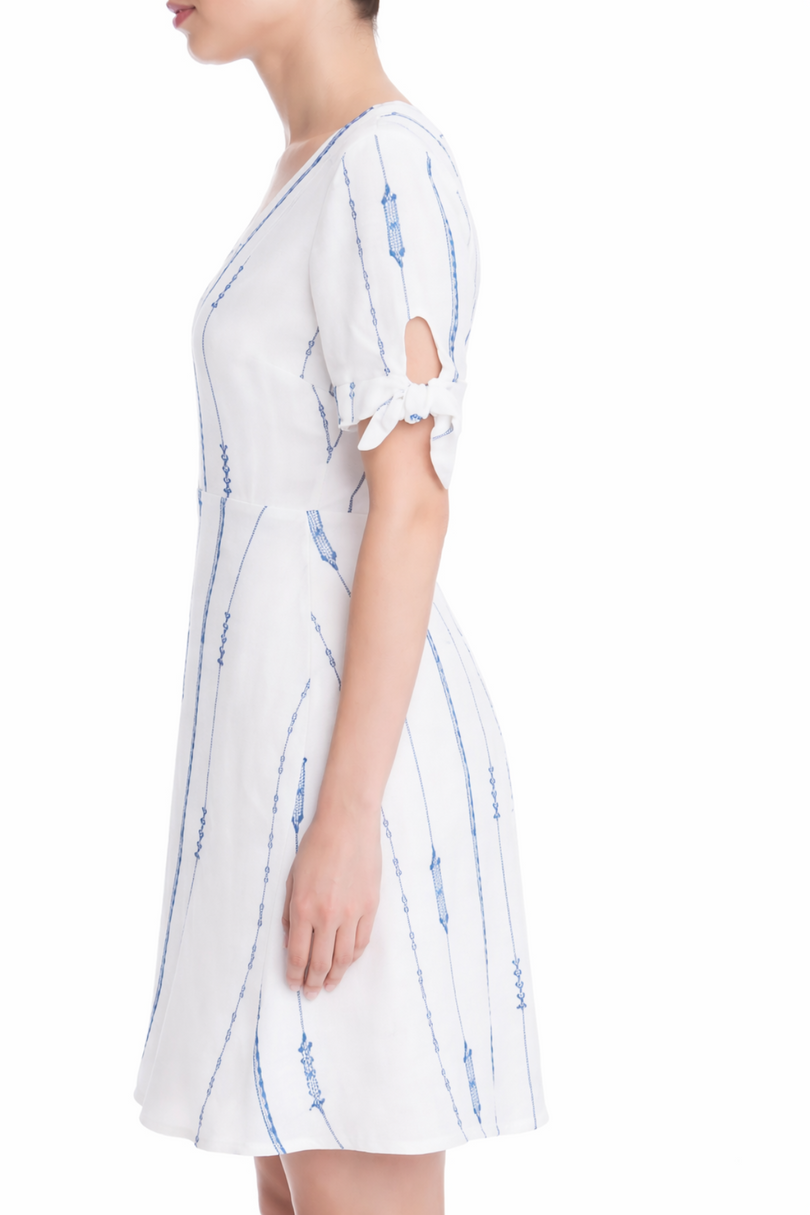 Side view of Capri White and Blue Embroidered A-line Mini Dress highlighting the V-neckline and adjustable short tie sleeves