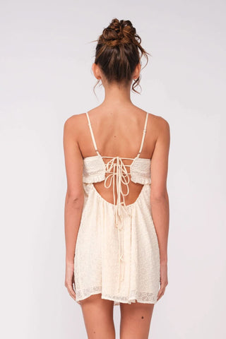 Back view of white eyelet babydoll mini dress with lace-up tie detail
