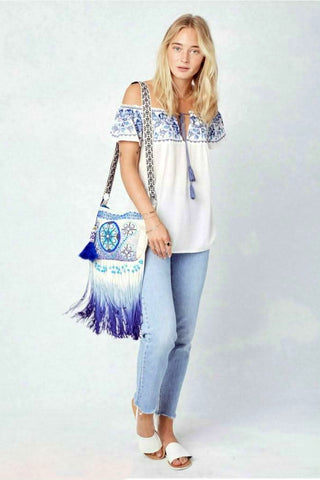 white embroidered off shoulder peasant top outfit with jeans and boho bag