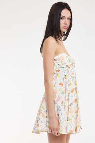 Side view of the white vacation print dress featuring beach chairs, umbrellas, and cocktails