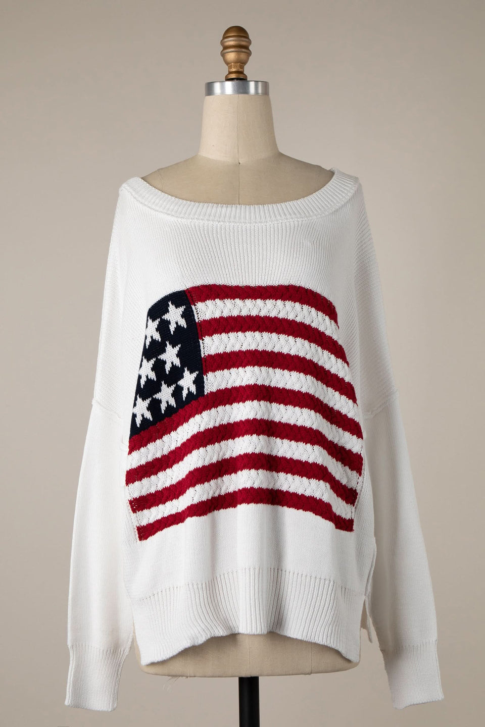 Oversized off-white sweater with a navy blue and white star patch and red and white stripes of the American flag