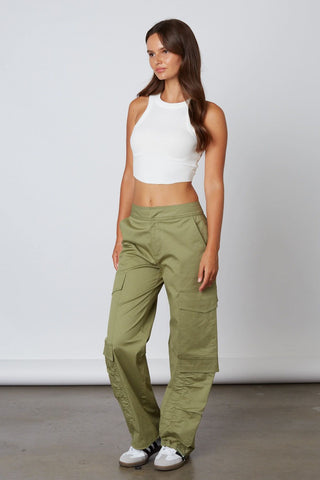 Model wearing baggy olive green sateen cargo pants with side pockets