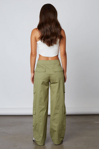 Model wearing baggy olive green sateen cargo pants with side pockets - Back View