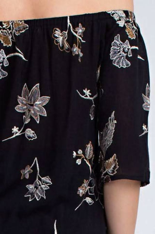 Close up view of a cute embroidered off-the-shoulder top