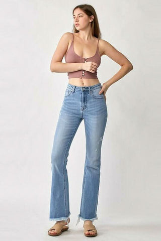 Lifestyle photo of a woman wearing flared denim jeans with a summer top