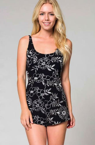 Model wearing a chic black and silver embroidered romper for a night out look.