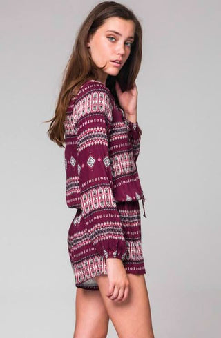 Side view of burgundy long sleeve boho print romper