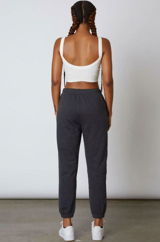 Back view of a pair of charcoal grey sweatpants showing the elastic waistband 