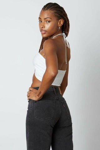 Back view of a white multi-way halter crop top showing the tie-neck closure