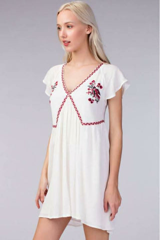 White summer babydoll dress with embroidered empire waist and flared skirt