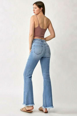 Back view of the distressed denim fabric and frayed hem detail on flare jeans