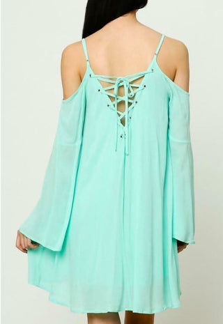 Mint cold shoulder shift dress with long bell sleeves styled for the beach - back view