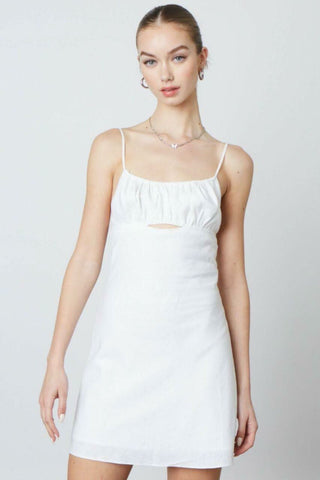 Woman wearing the Luna white A-line mini dress styled for graduation