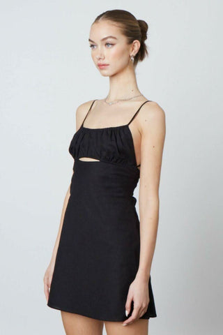 Side profile of the Luna black mini dress featuring a flattering A-line silhouette